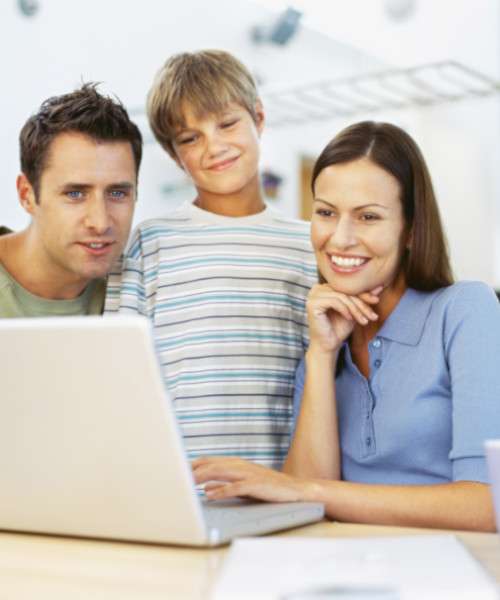 Des parents et leur enfant devant un ordinateur qui regardent le programme famille d'Acadomia